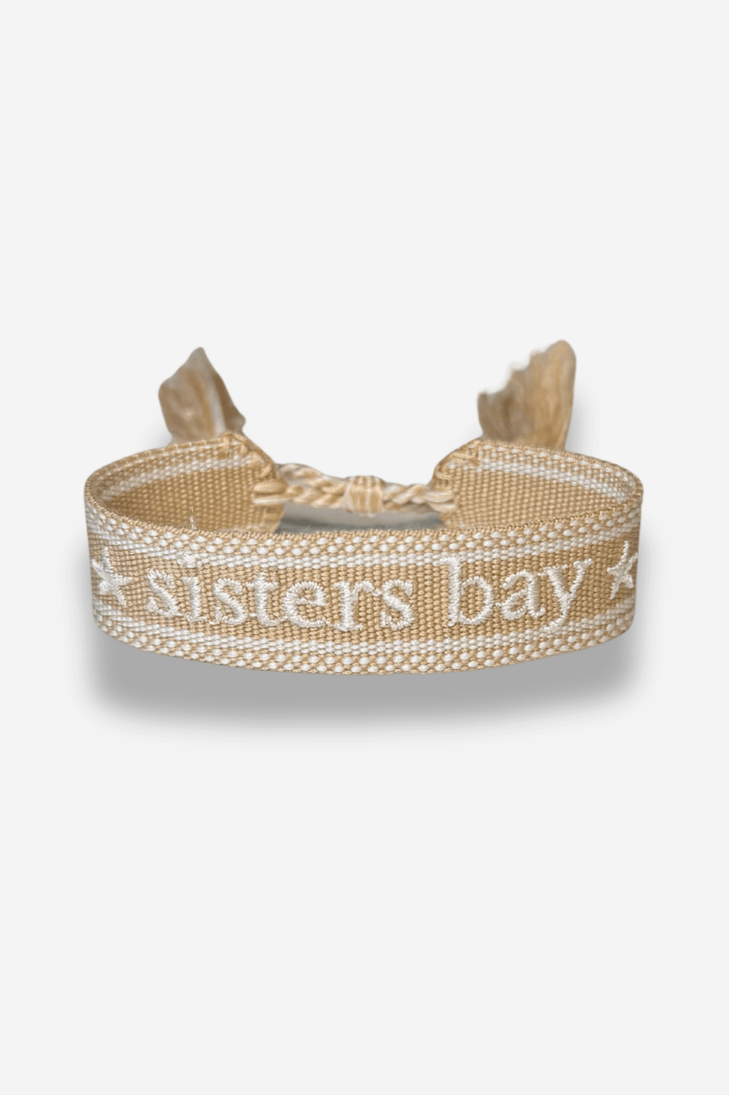 Bracelet tissé beige, création exclusive Sisters Bay, brodé « ★ sisters bay ★ » avec longueur ajustable grâce à un nœud coulissant.