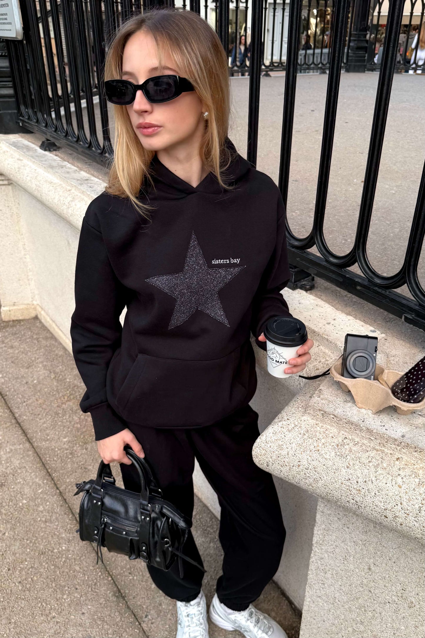 Sweat GLITZ noir brodé argenté, hoodie femme tendance avec motif étoile. Coton ringspun, polyester recyclé et poche téléphone intégrée. Style chic & confortable.