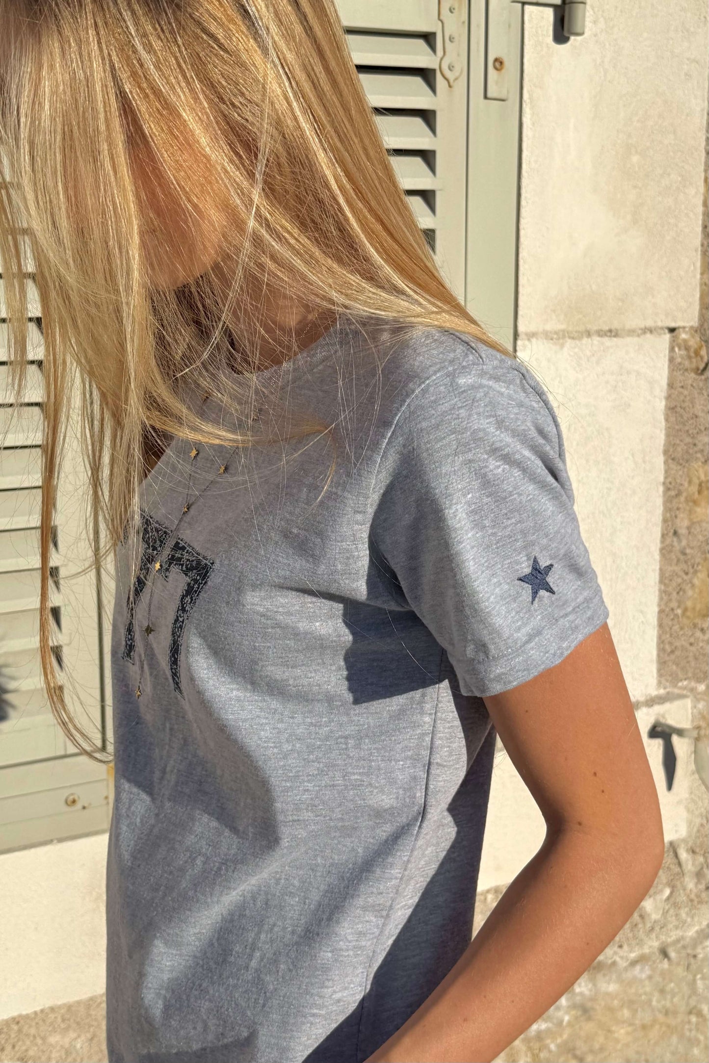 Détail du T-shirt 77 : étoile brodée sur la manche et motif fleuri.