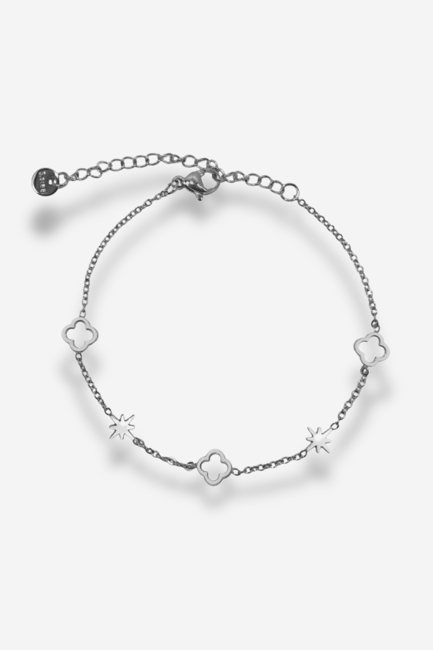 Bracelet en acier inoxydable avec étoiles et trèfles, ajustable grâce à une chaînette d’extension. Disponible en doré ou argenté.