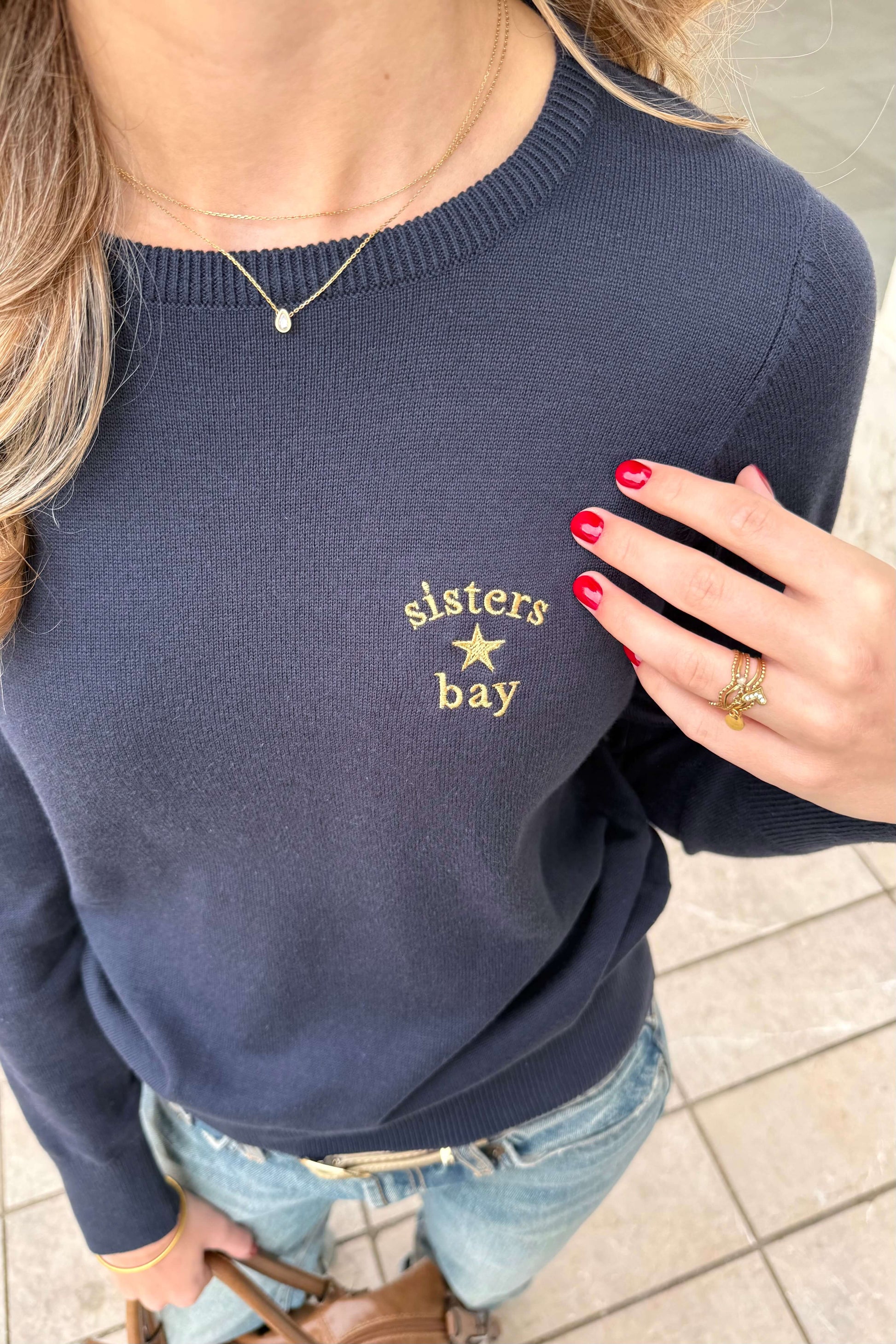 Gros plan sur le logo doré brodé sur le pull Sailor navy Sisters Bay, broderie réalisée dans notre atelier
