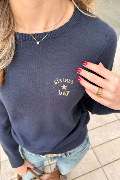 Gros plan sur le logo doré brodé sur le pull Sailor navy Sisters Bay, broderie réalisée dans notre atelier