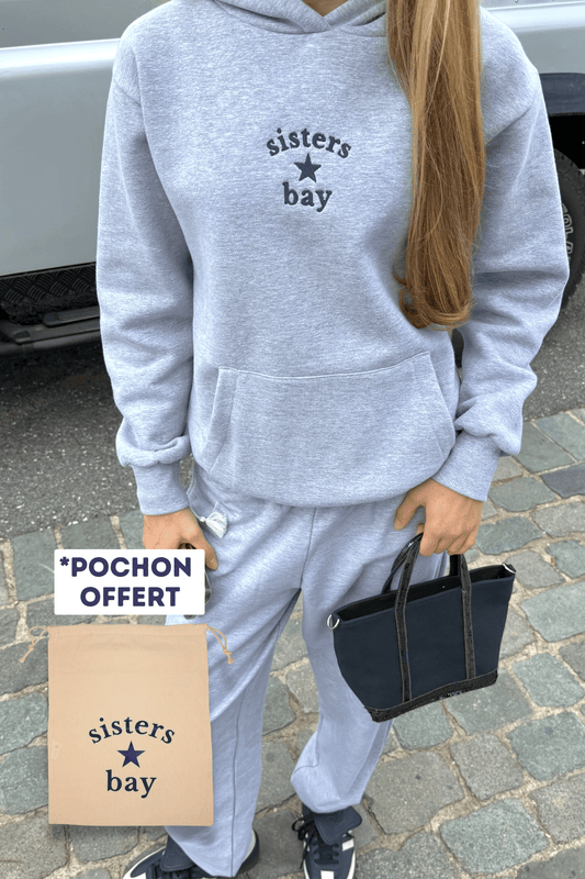 Création exclusive Sisters Bay. Ensemble composé d’un sweat-shirt et d’un jogging gris brodés, livré avec un pochon cadeau offert.