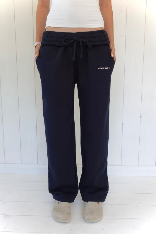 Jogging Bayclub Navy Sisters Bay en taille basse, avec sa ceinture réversible et sa broderie BAYCLUB baby pink.
