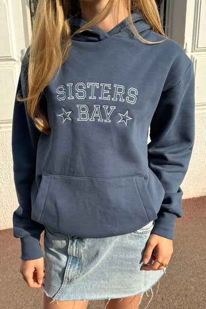 Détail de la broderie bleu clair sur le sweat-shirt Sisters Bay, coupe classique unisexe, coton ringspun et polyester recyclé.