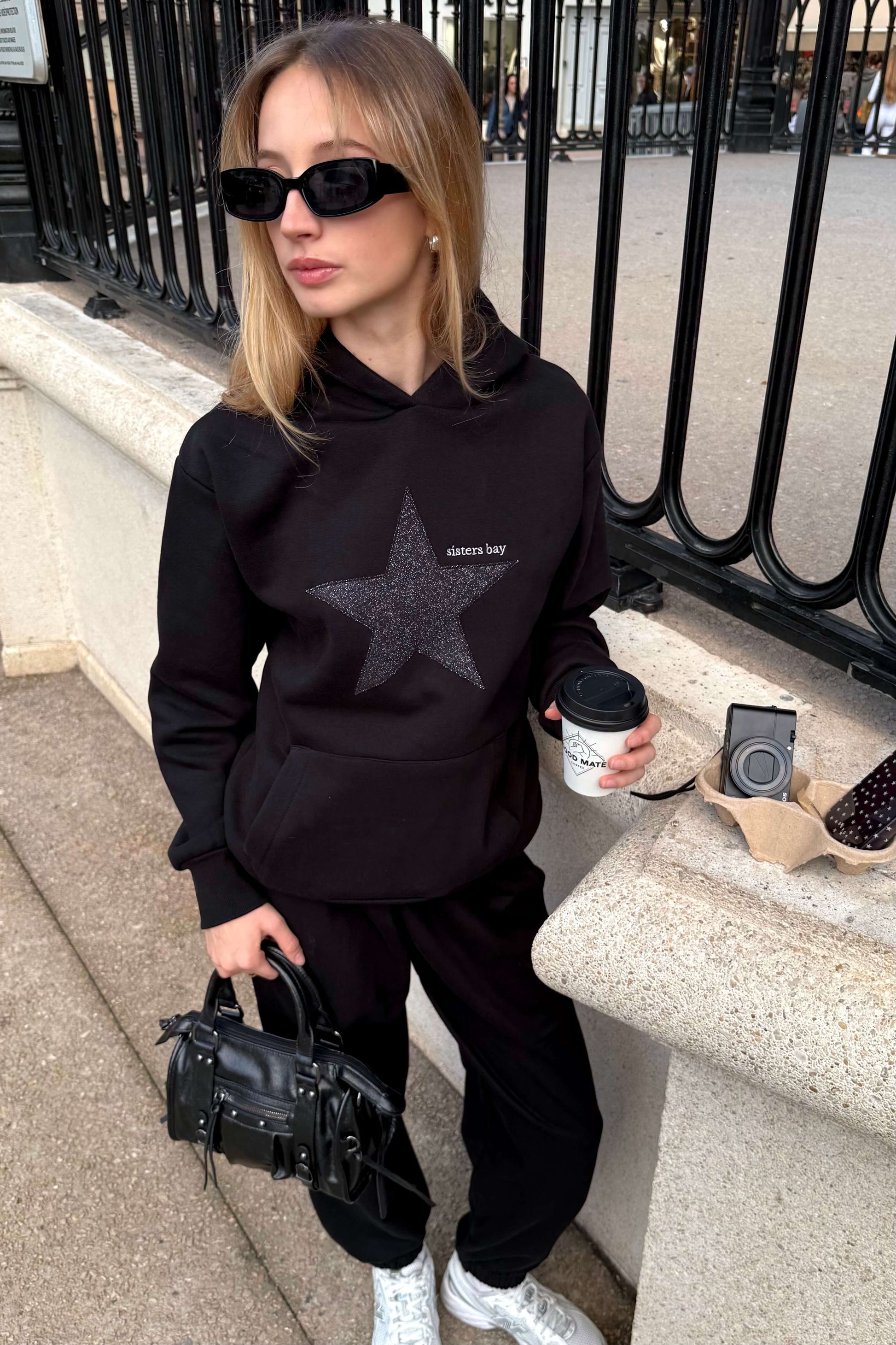 Sweat GLITZ noir brodé argenté, hoodie femme tendance avec motif étoile. Coton ringspun, polyester recyclé et poche téléphone intégrée. Style chic & confortable.