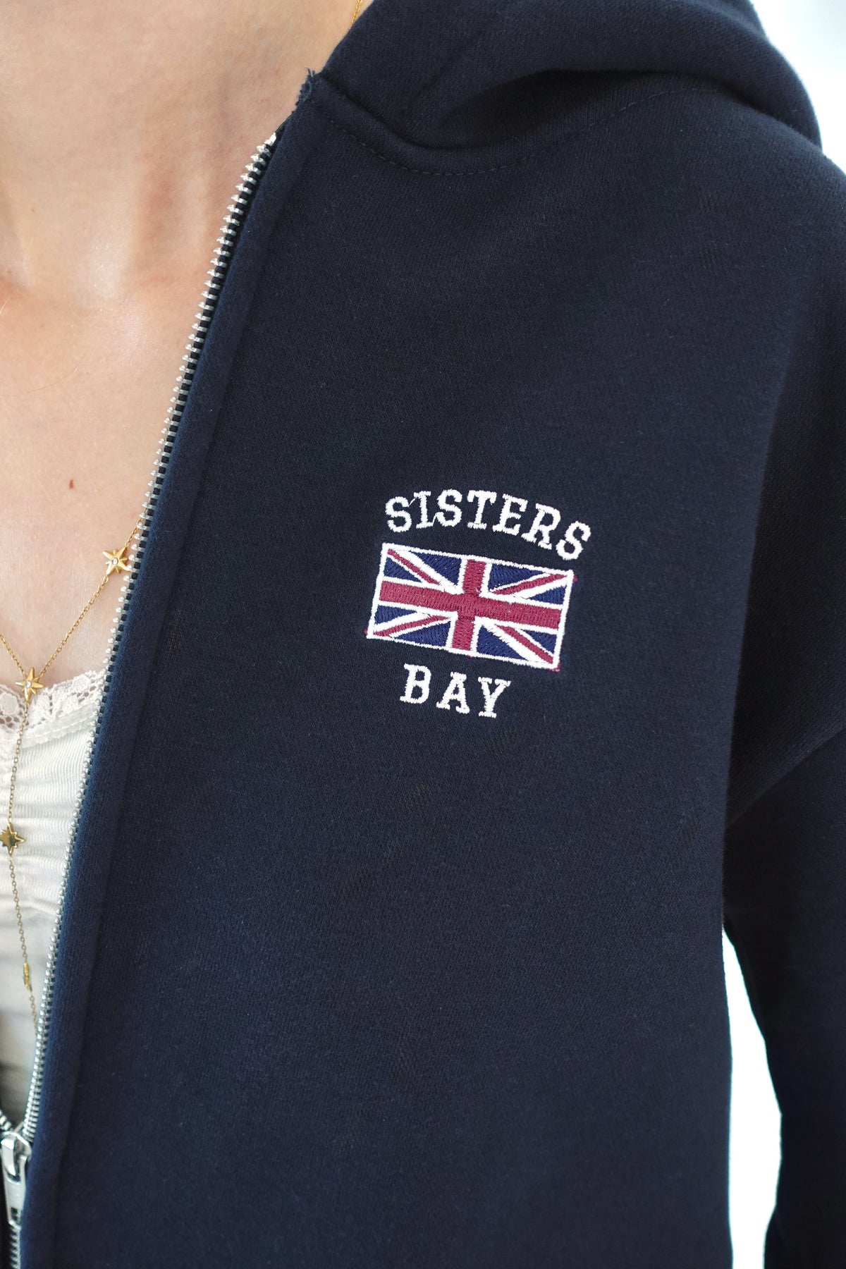 Gros plan sur la broderie London de la veste Navy Sisters Bay, un détail tendance au style britannique pour femme et adolescente.