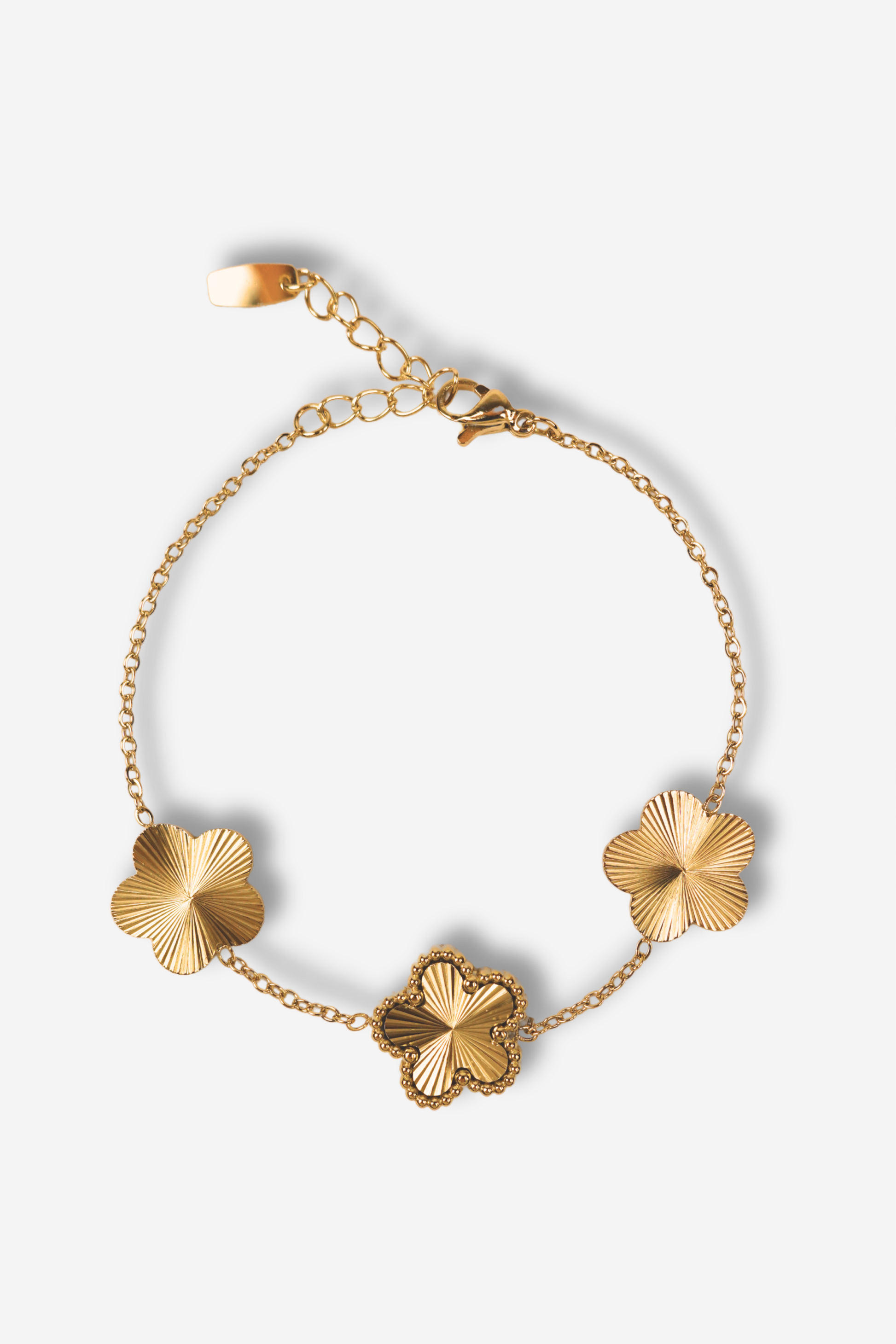 Bracelet AURA en acier inoxydable doré avec 3 fleurs décoratives. Longueur ajustable, résistant à l'eau et durable. Disponible sur Sisters Bay.