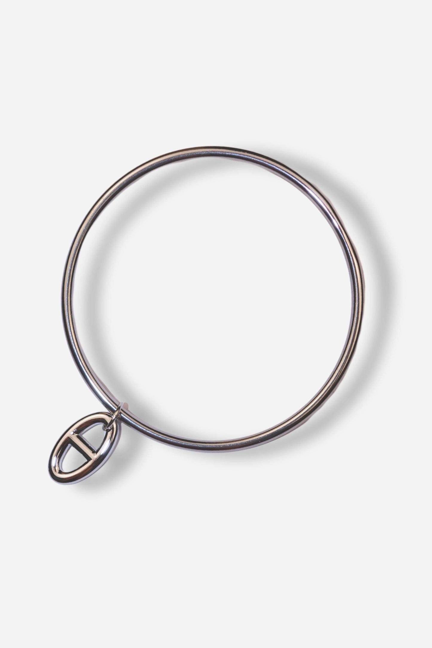 Bracelet jonc MUSE en acier inoxydable argenté, avec une breloque. Taille unique (70 mm). Disponible sur Sisters Bay.