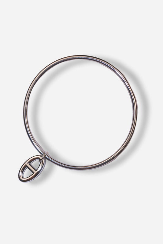 Bracelet jonc MUSE en acier inoxydable argenté, avec une breloque. Taille unique (70 mm). Disponible sur Sisters Bay.