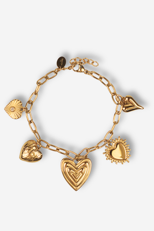 Bracelet LOVE GLOW doré en acier inoxydable avec breloques en forme de cœur. Résistant à l'eau, sans nickel, et ajustable. Disponible sur Sisters Bay.